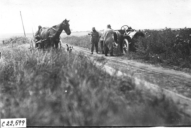 Horse-drawn vehicle approaches Moline car on rural road in Kansas, at 1909 Glidden Tour