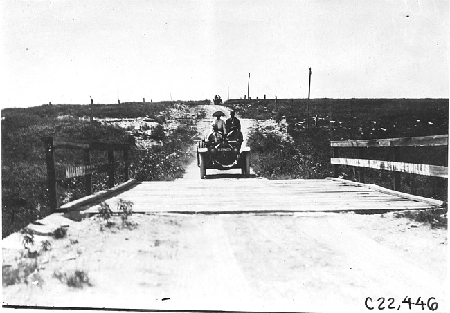 Marmon car approaching wooden bridge near Bunker Hill, Kan., at 1909 Glidden Tour