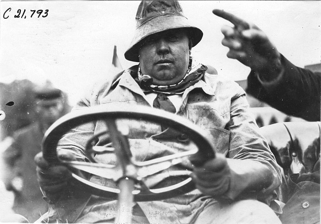 Geo. Smithson posed behind the wheel of Studebaker, at 1909 Glidden Tour