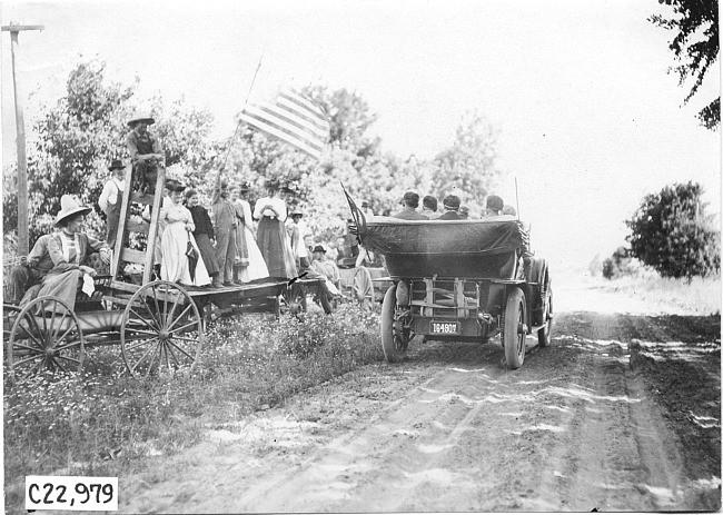 Studebaker car on rural road passing onlookers, at 1909 Glidden Tour