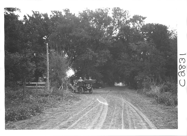 E.M.F. car on wooded road, on pathfinder tour for the 1909 Glidden Tour