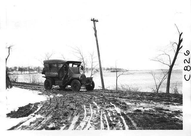 E.M.F. car on muddy, rutted road, on pathfinder tour for 1909 Glidden Tour