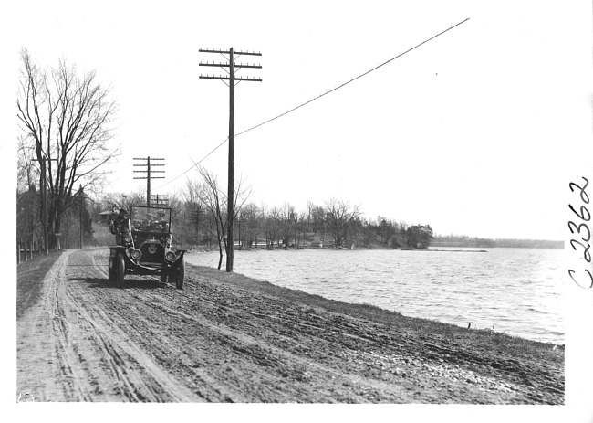 E.M.F. car on rural road by lake, on pathfinder tour for 1909 Glidden Tour