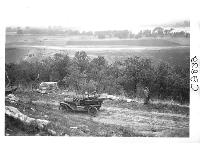 E.M.F. car on rural road overlooking farm land, on pathfinder tour for 1909 Glidden Tour