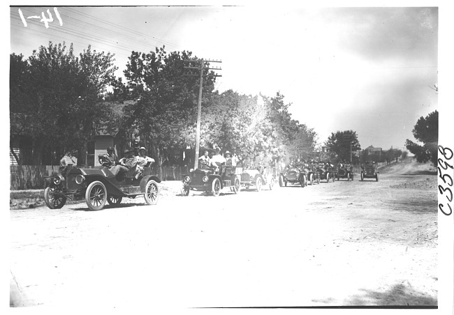 E.M.F. car leading a line of cars on residential street, on pathfinder tour for 1909 Glidden Tour