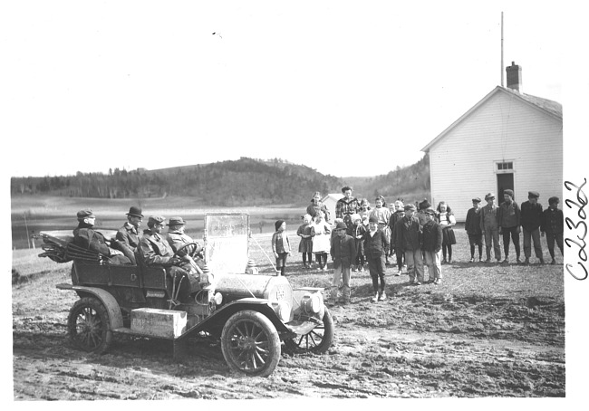 E.M.F. car parked near school, students look on, on pathfinder tour for 1909 Glidden Tour