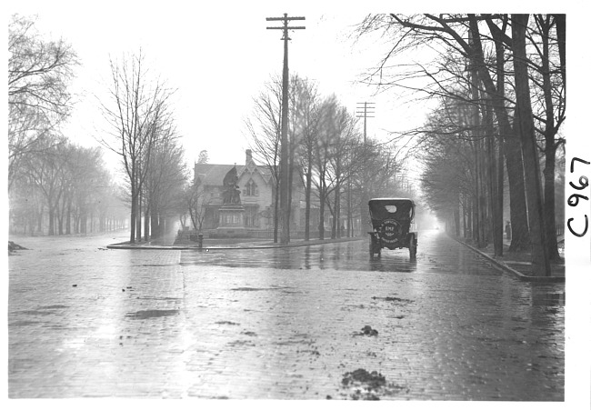 E.M.F. car on cobblestone street in rain, on pathfinder tour for 1909 Glidden Tour