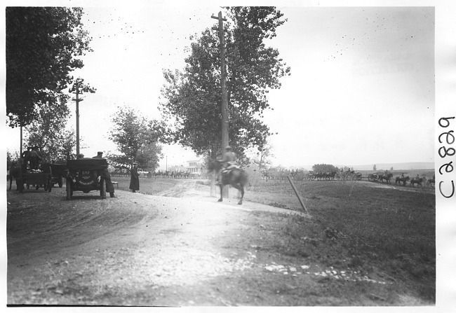 E.M.F. car parked on side of road, men on horses in background, on pathfinder tour for 1909 Glidden Tour