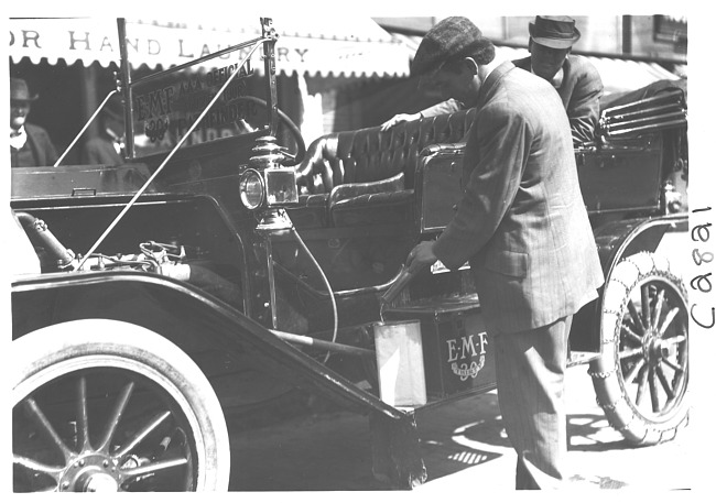 E.M.F. car with man pouring gasoline, on pathfinder tour for 1909 Glidden Tour