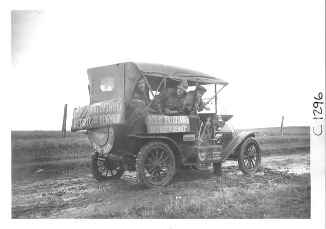 E.M.F. car with top raised on muddy road, on pathfinder tour for 1909 Glidden Tour