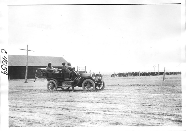 E.M.F. car parked near barn with cows, on pathfinder tour for 1909 Glidden Tour