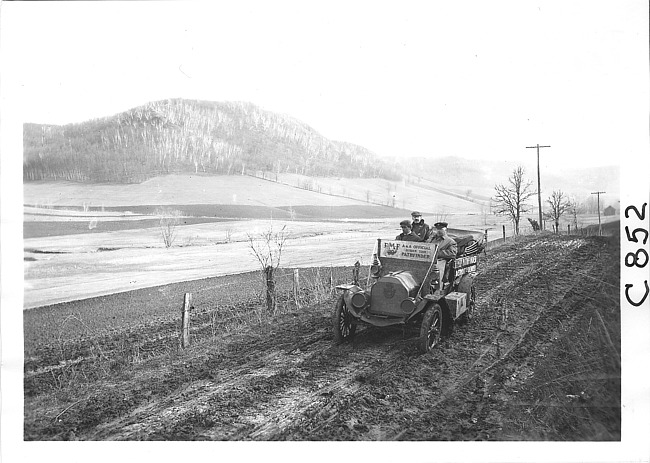 E.M.F. car on muddy rural road, on pathfinder tour for 1909 Glidden Tour