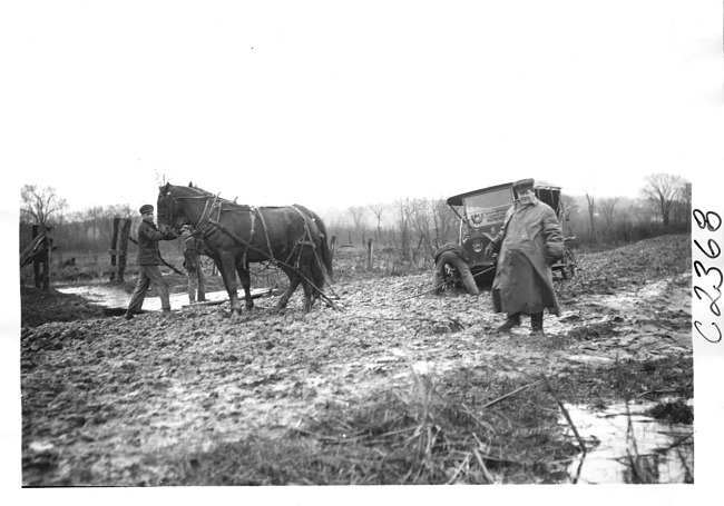 E.M.F. car being pulled from mud, on pathfinder tour for 1909 Glidden Tour