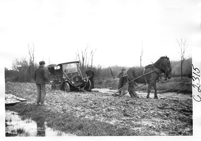 E.M.F. car being pulled from mud, on pathfinder tour for 1909 Glidden Tour