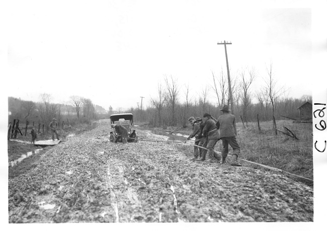 E.M.F. car being pulled from mud, on pathfinder tour for 1909 Glidden Tour