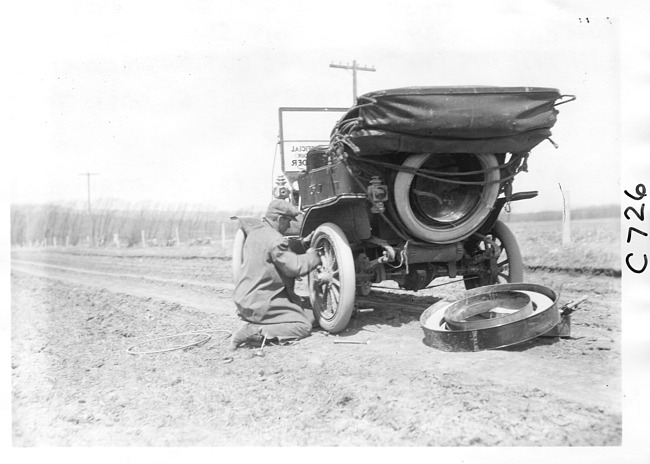 E.M.F. car getting a tire change, on pathfinder tour for 1909 Glidden Tour