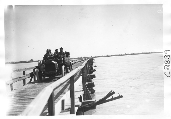 E.M.F. car crossing wooden bridge, on pathfinder tour for 1909 Glidden Tour