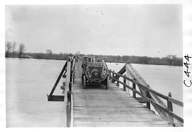E.M.F. car crossing wooden bridge, on pathfinder tour for 1909 Glidden Tour