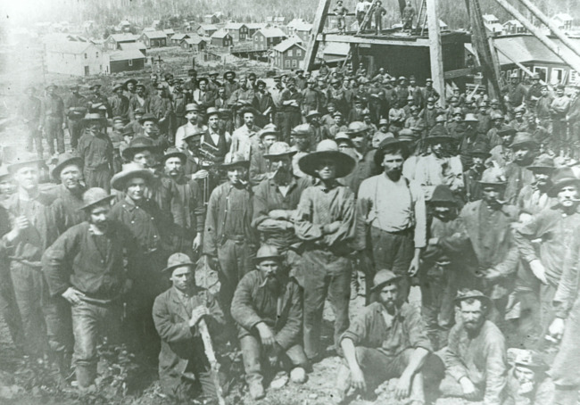 Early view of Iron Mountain miners with shaft house in background