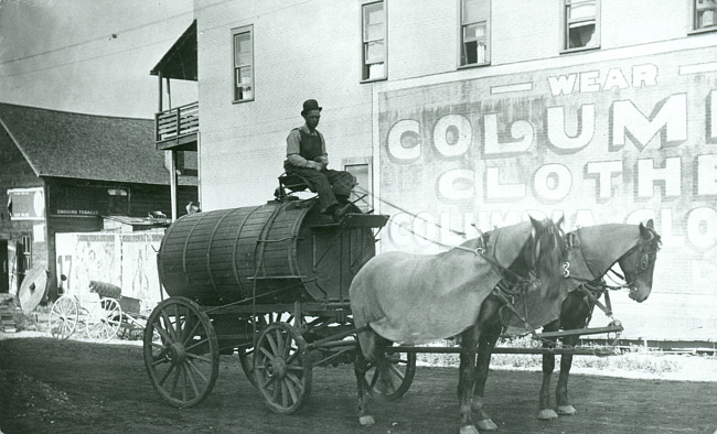 John Rule driving the sprinkling wagon over the streets of Iron Mountain