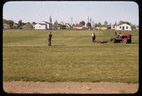 O. J. Noer takes a photograph of Scotty McLaren with a gang mower on a turf surface at the Toro Research Center, Toro Headquarters, Minnesota, 1955